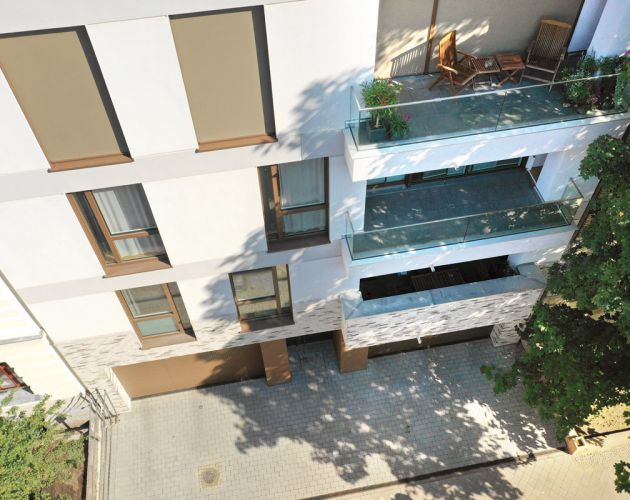 Moderne Wohnanlage mit Balkonen und grüner Umgebung aus Vogelperspektive.